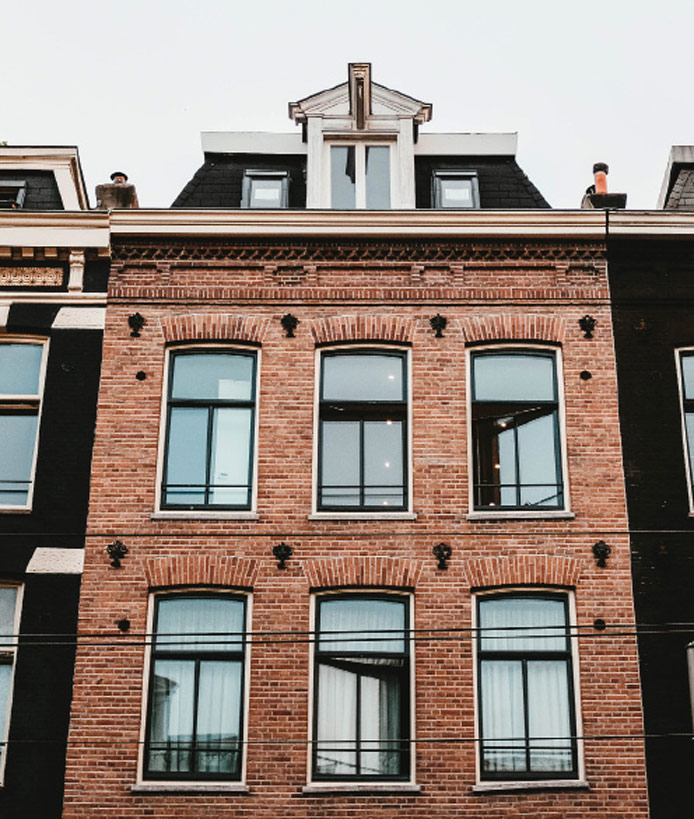 Een rij bakstenen gebouwen met ramen en balkons, perfect voor particulieren die een huis willen kopen met Rocket Hypotheken.
