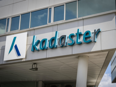 Gevel van het gebouw met een kadasterbord en logo in de kleuren blauw en wit.